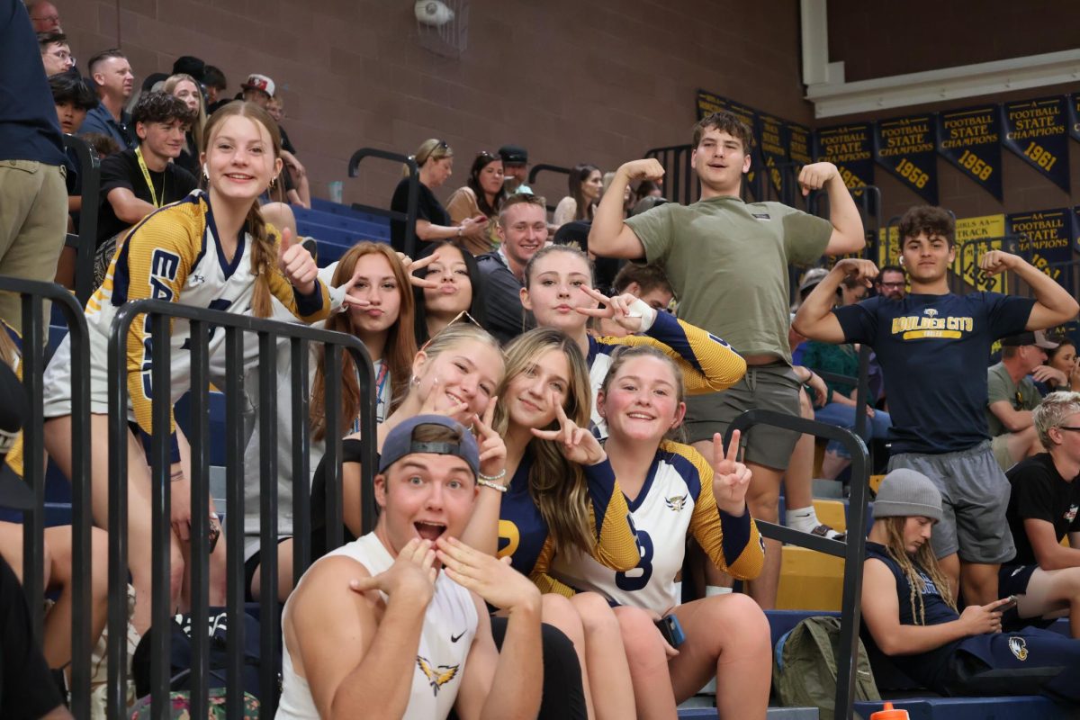 Students cheering on the Varsity Volleyball team.