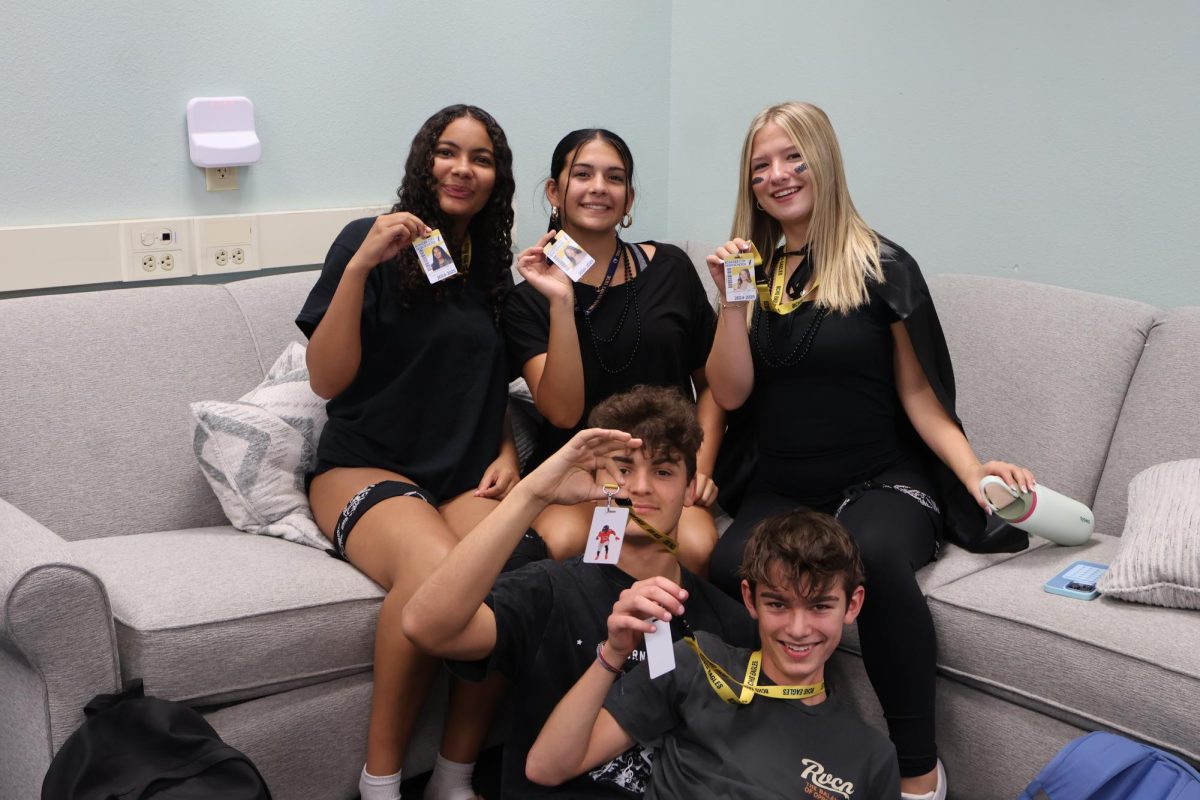 Juniors Amaya Henderson, Kaila Shelton and Zoe Fox (left to right) smiling with their lanyards. Junior Nate Lewis and sophomore Rion Conover joining them. 