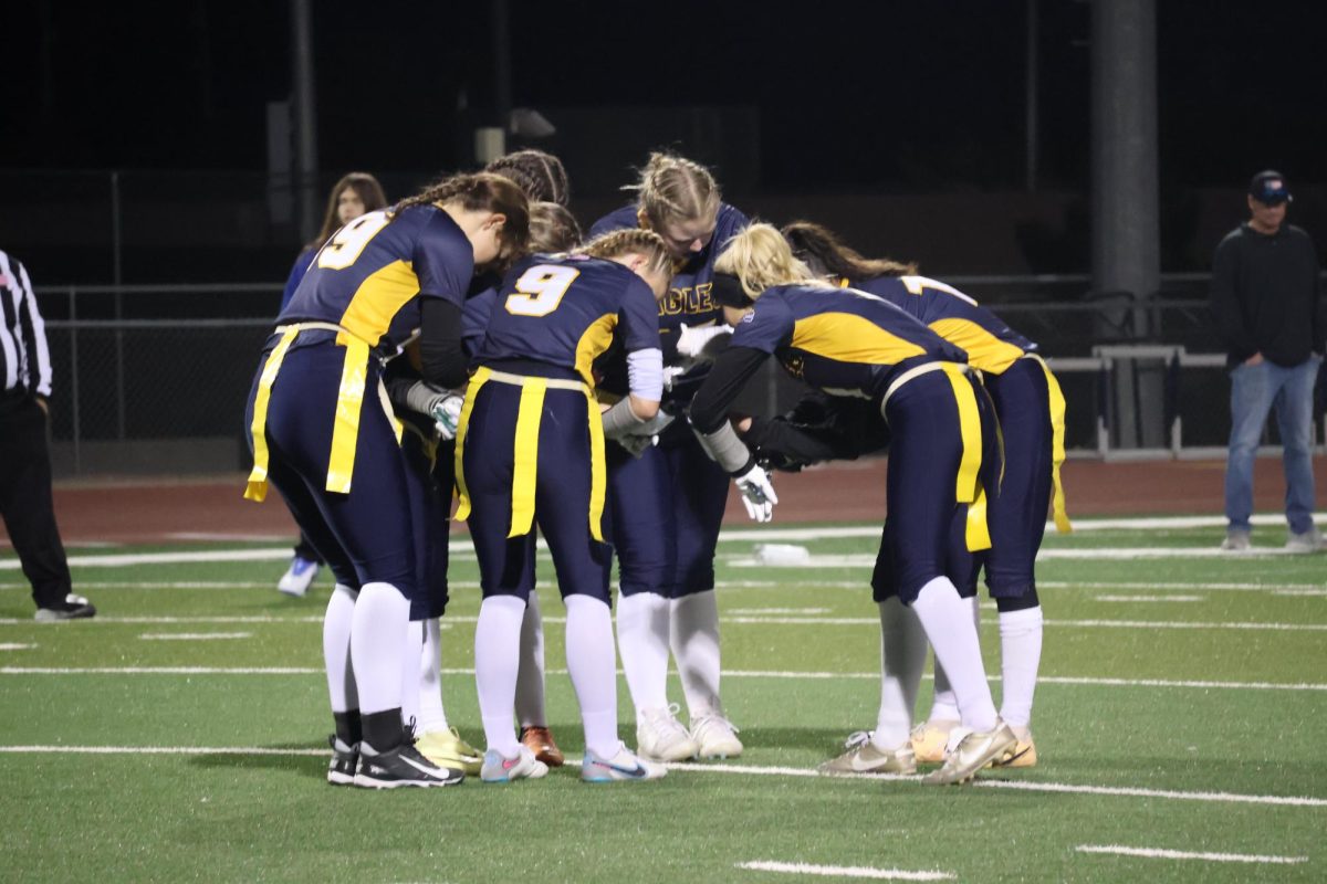 Varsity Flag Football huddling together and going over their upcoming play.